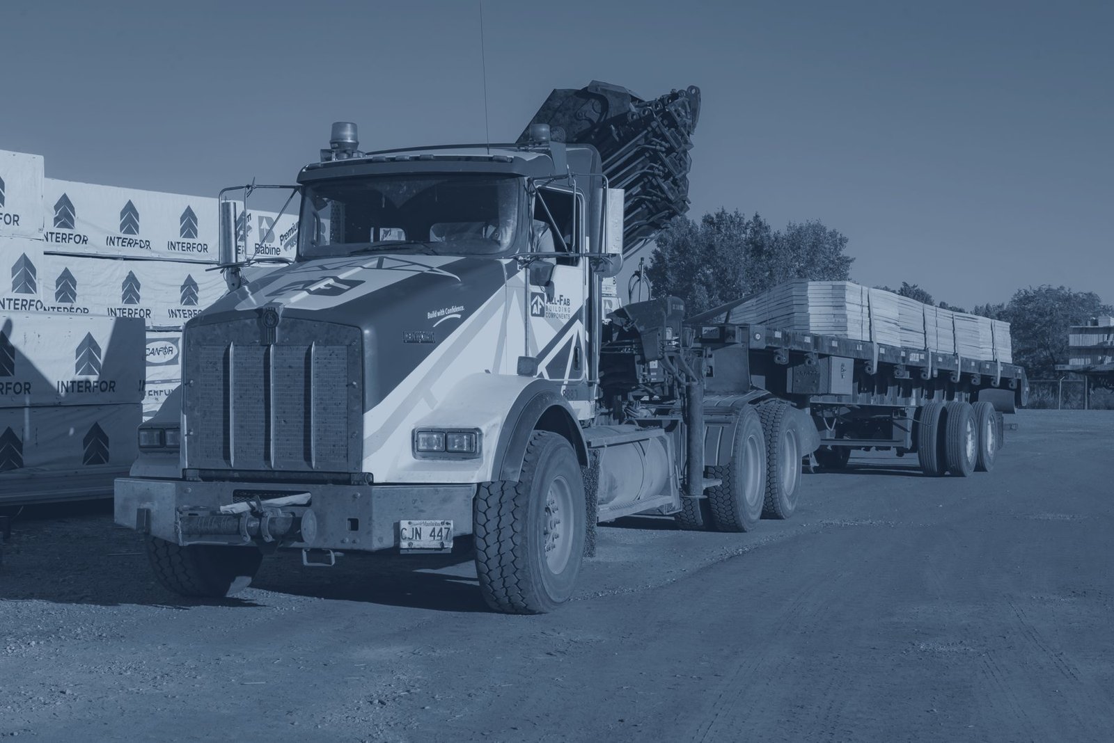 A crane truck delivering trusses